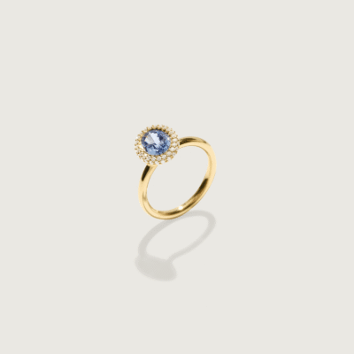 Cecile Bombé verlovingsring in 18k goud met 2,00 ct ovale blauwe saffier en dubbele kroon van witte briljanten op lichte achtergrond